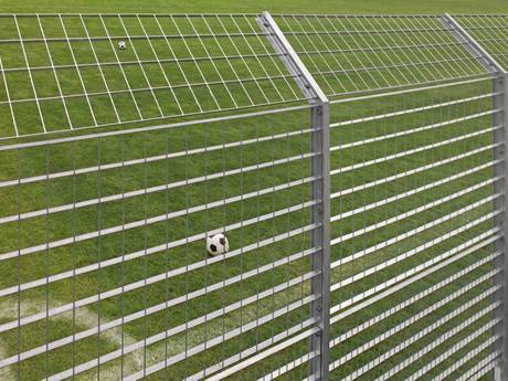 Galvanized steel grating fence around the football field and upper fence is slanting.