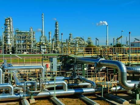 This is a oil refinery with many large oil pipes and oil tanks.