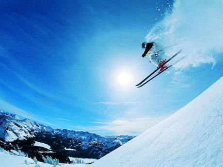 A person with ski board is skiing in the ski resort.