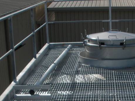 Un réservoir est sur le toit de la grille en acier.