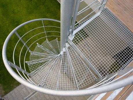 A spiral fire escape stair made from steel grating.