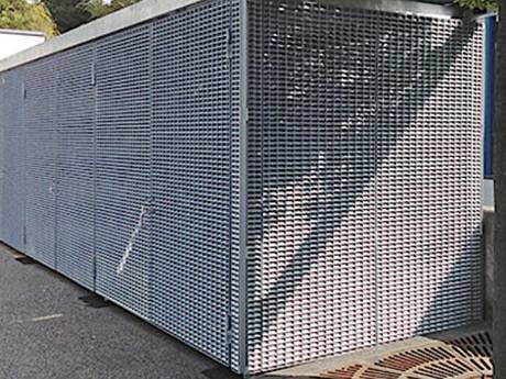 Un contenedor hecho de rejilla de acero galvanizado está en la calle.