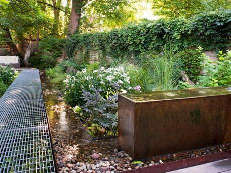 La grille en acier de jardin est utilisée comme passerelle et de nombreuses plantes des deux côtés.
