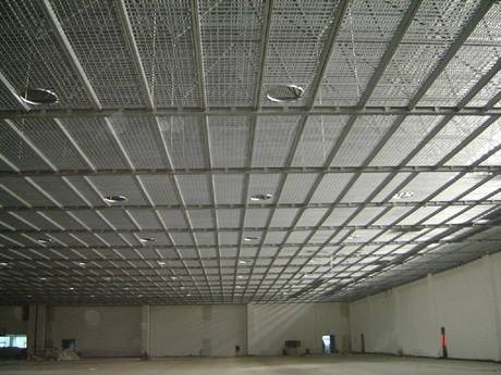 In a warehouse, the ceiling is divided into different sizes of rectangular, also some hollow circular areas scattered irregularly on it.