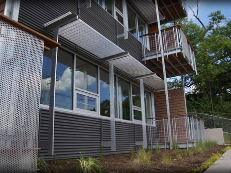 Ceci est une maison avec des panneaux d'ombrage en acier sur les prairies