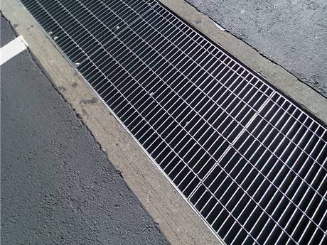 This welded steel grating gully cover on the street.