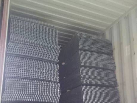 Several bundles of welded steel gratings in the container.