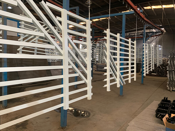 Aluminum fence after powder coating is hanging in the factory for drying.