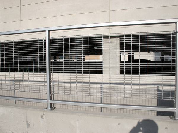 Varias piezas de rejillas trabadas de aluminio están soldadas en el marco como vallas de seguridad.