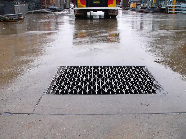 Diamond pattern steel grating applied in drainage systems for efficient water flow.