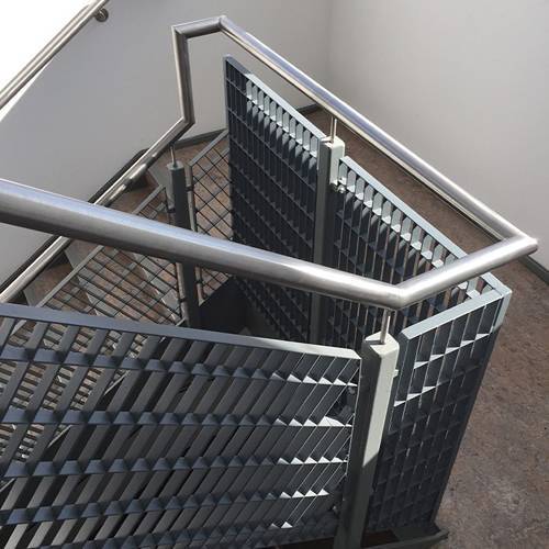 A corner of stair and the handrail infills are made of press lock grating.