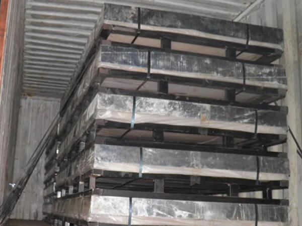 Several pallets of perforated steel grating in the container.