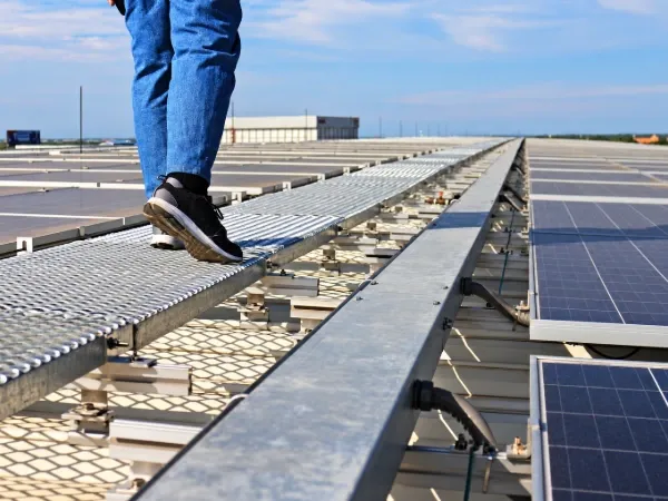 Person walking on rooftop solar panel walkways