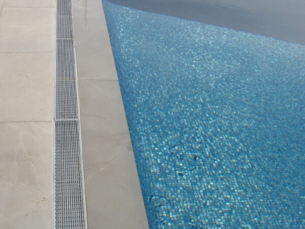 The polished stainless steel 304 wedge wire grates are installed around the swimming pool.