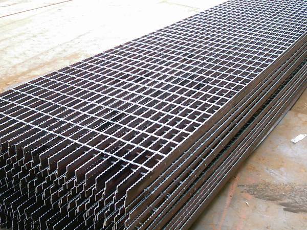 Several pieces of carbon steel steel grating on gray background.