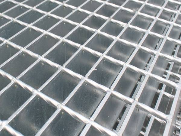 Several pieces of steel grating with plain surface on gray background.