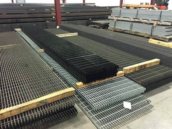 Varias piezas de rejillas de acero estándar se colocan en el almacén con acero al carbono, superficie galvanizada o negra.