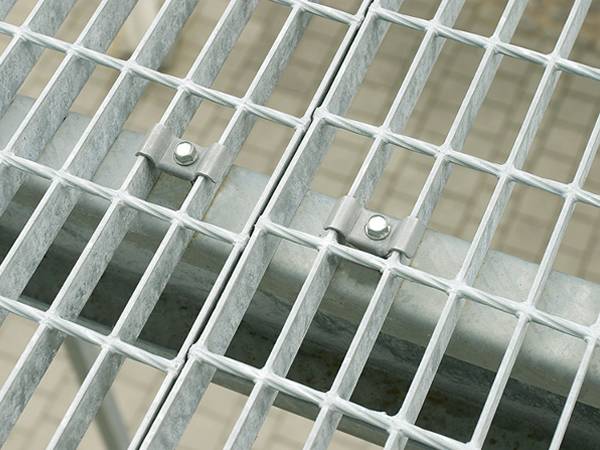 Deux pinces de selle sont installées sur la poutre de support pour la fixation de caillebotis en acier.
