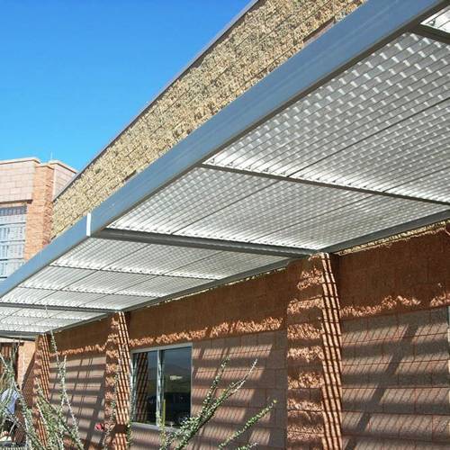 Galvanized steel gratings are installed above the door for sun shading.