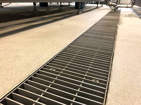 A line of aluminum swage locked grating tench cover is installed on the ground.