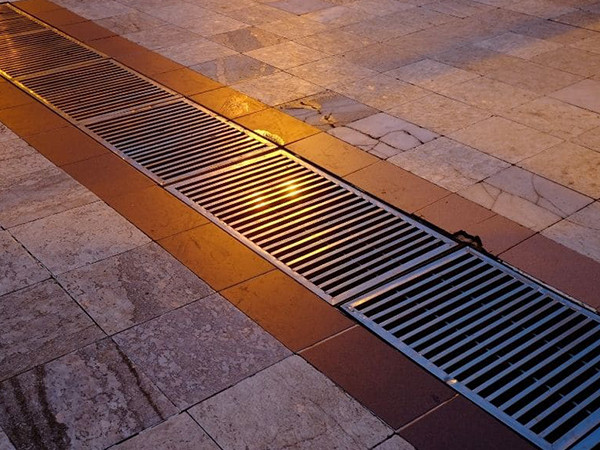 Trench grate and frame is laid as roadway.